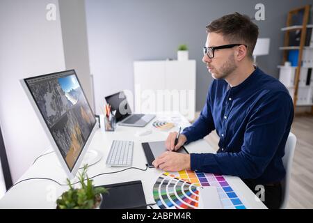 Vue arrière d'un homme travaillant sur le paysage 3D computer in Office Banque D'Images