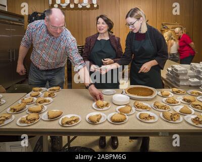 Des Moines, Iowa, USA. 28 Nov, 2019. Le sénateur américain Amy Klobuchar (D-MN), au centre, avec son mari, John Bessler et sa fille ABIGAIL BESSLER couper des tartes à la table de dessert dans le Sud Des Moines Community Centre. Klobuchar Sen a servi de repas de l'action de l'homme au centre. Klobuchar Sen fait campagne pour être le candidat démocrate pour la présidence des États-Unis. L'Iowa détient la première épreuve de sélection de l'élection présidentielle. Le caucus de l'Iowa sont 3 Février, 2020. Crédit : Jack Kurtz/ZUMA/Alamy Fil Live News Banque D'Images