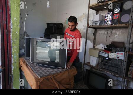 Un Palestinien la réparation d'appareils électroménagers en face de son magasin à Khan Younis, au sud de la bande de Gaza, le Nov 28, 2019. Photo par Abed Rahim Khatib Banque D'Images