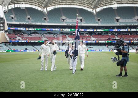 Adelaide, Australie, 29 novembre 2019. Un jeune porteur de drapeau avec le drapeau national de l'Australie Australian accompagne le capitaine Tim Paine (gauche) Nathan Lyon (centret) après l'interprétation des hymnes nationaux cérémonie le jour un de la 2e journée de domaine test de nuit entre l'Australie et le Pakistan à l'Adelaide Oval. L'Australie mène 1-0 dans la série 2 .match Crédit : amer ghazzal/Alamy Live News Banque D'Images