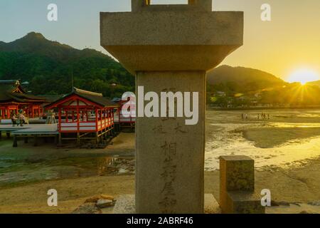 Miyajima, JAPON - 13 octobre 2019 - Vue du coucher de soleil du sanctuaire d'Itsukushima, à marée basse, avec les visiteurs, dans l'île d'Itsukushima (Miyajima), Japon Banque D'Images