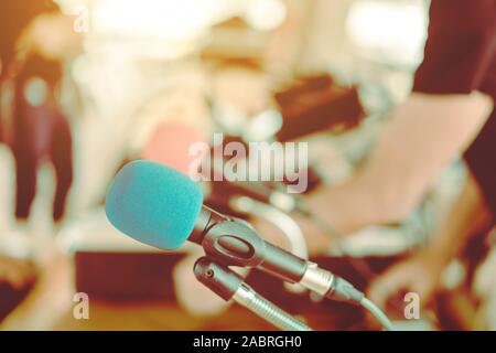 Deux microphones avec éponges bleu et rouge sur un support placé avec écouteurs sur la table avec l'image du barbouillage du technicien audio a été l'installation et le sev Banque D'Images