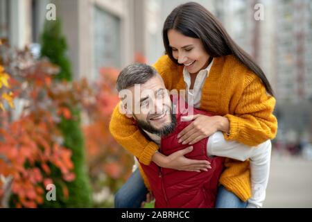 Je suis fort. Heureux l'homme bien bâti portant sa petite amie en passant son temps avec elle Banque D'Images