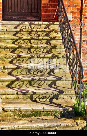 Ombre de la rambarde sur un ancien escalier en pierre. Banque D'Images