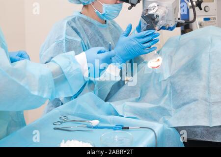 Donner un outil à l'infirmière un médecin lors de la chirurgie. Mains des médecins au cours de la chirurgie de l'hôpital. Chirurgie de l'oreille Banque D'Images