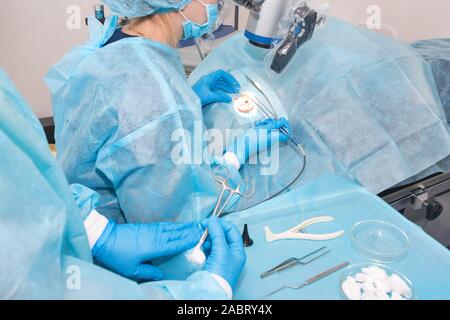 Donner un outil à l'infirmière un médecin lors de la chirurgie. Mains des médecins au cours de la chirurgie de l'hôpital. Chirurgie de l'oreille Banque D'Images