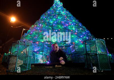 Gordon Wink se trouve sous le sapin de Noël 16 pi, qu'il a contribué à construire sur le port-côte dans Ullapool, Wester Ross, qui est créé à partir de 340 à la nasse de pêche utilisés pour la capture de crevettes et crabes. Banque D'Images