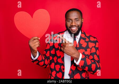 Photo de l'homme drôle dark skin cupidon tenir grande forme de coeur papier indiquant l'usure des doigts carte postale créative motif coeurs Élégant blazer costume shirt Banque D'Images