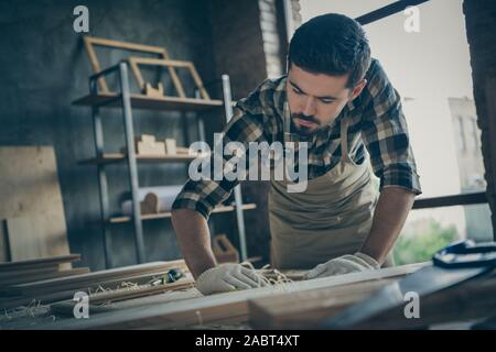 L'angle ci-dessous bas voir photo de confiance grave concentré réfléchie axée sur l'homme de bois du châssis polissage avec du papier émeri Banque D'Images