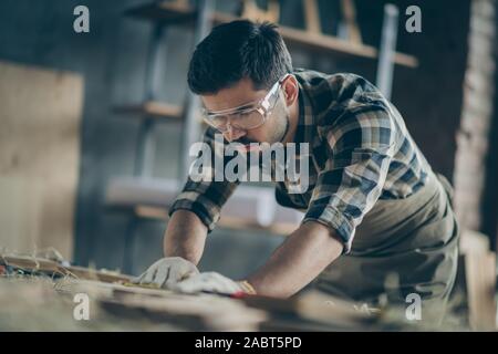 Portrait de son joli accent attrayant il qualifiés travailleurs expérimentés concentré guy builder créer des meubles en bois de la sculpture moderne au Banque D'Images