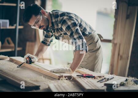 Portrait de son joli accent attrayant il professionnel concentré connu guy bois sculpture spécialiste de la création de nouveaux meubles modernes au projet Banque D'Images