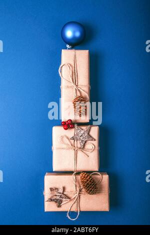 Cadeaux de Noël Décoration avec énoncés dans la forme d'un arbre de Noël sur fond bleu, vue de dessus. Banque D'Images