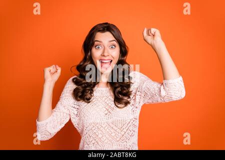 Portrait de jeune fille surpris entendre loterie incroyable win news scream wow coucou soulever fists porter mignon équipement moderne sur fond de couleur orange isolé Banque D'Images