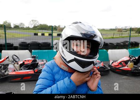 12-year-old boy taking off un casque équitation après un rendez-kart à Cabourg, France. Banque D'Images