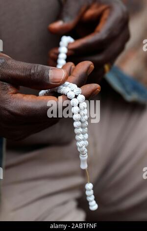 Musulmans de l'Afrique de l'homme qui prie. Perles de prière islamique (tasbih). Gros plan sur les mains. Le Togo. Banque D'Images