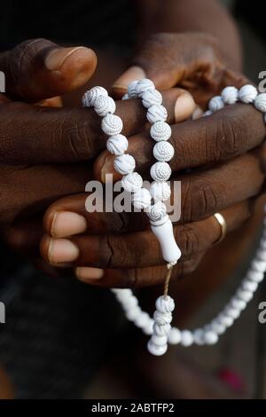 Musulmans de l'Afrique de l'homme qui prie. Perles de prière islamique (tasbih). Gros plan sur les mains. Le Togo. Banque D'Images