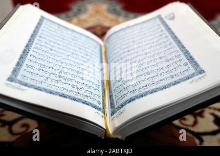 Un Coran en arabe sur le stand en bois. Banque D'Images