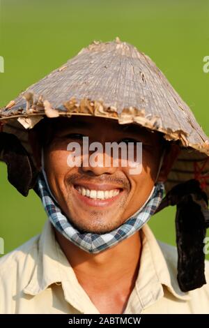 Farmer portant un vieux chapeau conique traditionnel de la feuille de palmier. Portrait. Hoi An. Le Vietnam. Banque D'Images