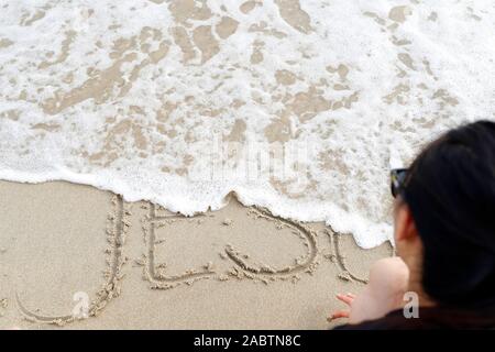 Le mot Dieu dans le sable lavé par la mer. Le Vietnam. Banque D'Images