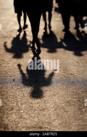 Groupe de personnes à pied et en projetant de longues ombres sur la rue. Hanoi. Le Vietnam. Banque D'Images