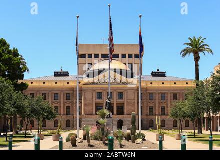 Phoenix, Arizona, USA - Le 25 mai 2019 : l'avant de l'Arizona Capitol Museum au cours de la journée au soleil. Flaggs und saguaros sont au premier plan. Banque D'Images