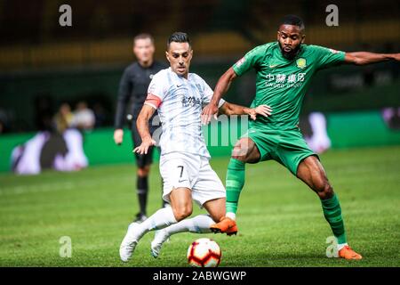 Joueur de football israélien Eran Zahavi de Guangzhou R&F F.C., gauche, protège la balle au cours du 29e match de football chinois Super League (CSL) contre Pékin Guoan Sinobo dans la ville de Guangzhou, province du Guangdong en Chine du sud, le 27 novembre 2019. Guangzhou R&F en chute de Beijing Guoan Sinobo avec 1-4. Banque D'Images