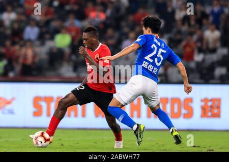 Joueur de football camerounais Jean Marie de Shenzhen F.C., gauche, protège la balle au cours du 29e match de football chinois Super League (CSL) contre le Henan Jianye dans la ville de Shenzhen, province du Guangdong en Chine du sud, le 27 novembre 2019. Shenzhen C.F. lié le jeu avec le Henan Jianye avec 3-3. Banque D'Images