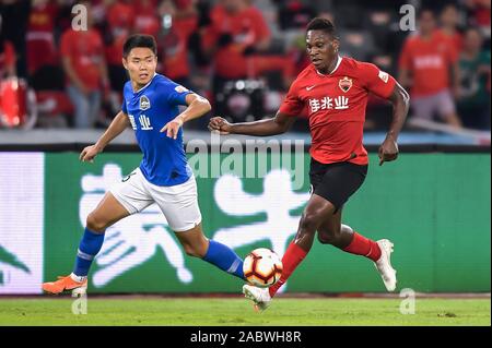 Joueur de football camerounais Jean Marie de Shenzhen F.C., droit, protège la balle au cours du 29e match de football chinois Super League (CSL) contre le Henan Jianye dans la ville de Shenzhen, province du Guangdong en Chine du sud, le 27 novembre 2019. Shenzhen C.F. lié le jeu avec le Henan Jianye avec 3-3. Banque D'Images