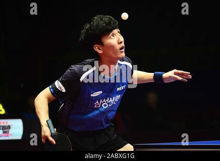 Lee Sang-su de la Corée du Sud sert de Jai Kanak contre USA dans leur masculin match du groupe B au cours de l'ITTF 2019 Coupe du Monde à Chengdu City, Banque D'Images