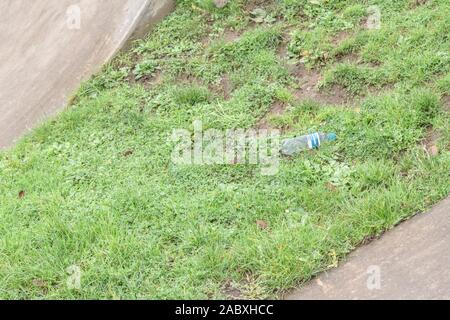 Les boissons gazeuses en plastique vide bouteille / déchets sur patch d'herbe. Métaphore le recyclage, la pollution, les déchets de bouteilles en plastique, bouteille en plastique vide. Banque D'Images