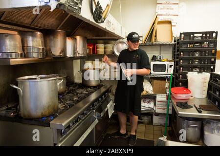 Un jeune homme haricots cuisiniers dans la cuisine des plus vieux peuplement coney en Amérique, Fort Wayne's célèbre Wiener Coney Island Stand. Banque D'Images