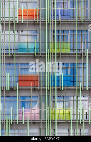 La façade d'un bâtiment résidentiel moderne, une solution d'architecture abstraite, multi-panneaux transparents de couleur bleu rouge vert et tubes de métal. Text Banque D'Images