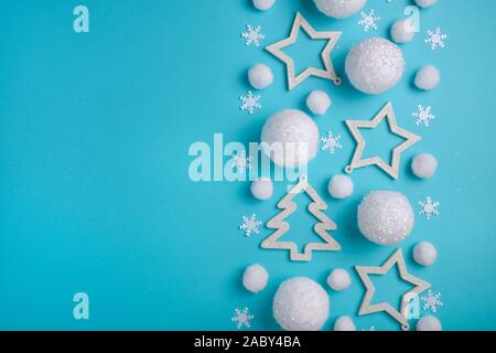 Noël, Nouvel An border fait de boules blanches, neige, étoiles et arbre de Noël. Motif de fête de neige fond bleu clair Banque D'Images