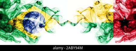 Brésil, brésilien vs Guinée Bissau smoky mystic drapeaux placés côte à côte. Couleur épaisse fumée combinaison drapeaux soyeux abstract Banque D'Images