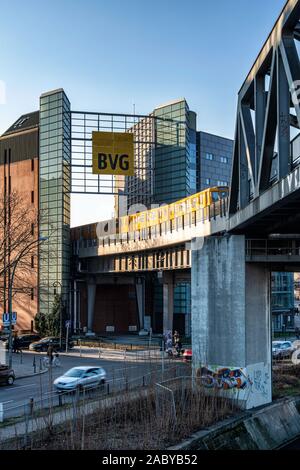 Bâtiment moderne avec BVG Berlin trin jaune soulevé sur viaduc passant entre deux bâtiments de Berlin, Kreuzberg Banque D'Images