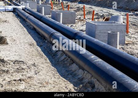 Black isolées pour le chauffage urbain souterrain et des trous de drainage pour la construction de l'eau de tempête. Connecter un nouveau bâtiment à la chaleur du système. Banque D'Images