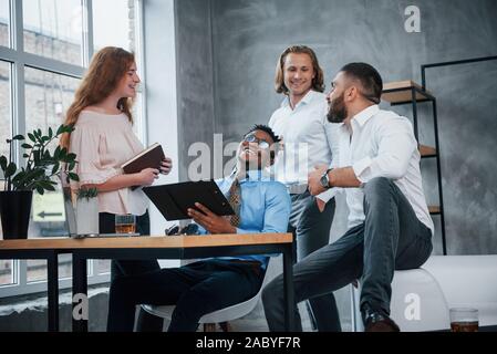 Comment trouver un travail. Groupe d'employés de bureau dans une société multiraciale vêtements parle de plans et les tâches Banque D'Images