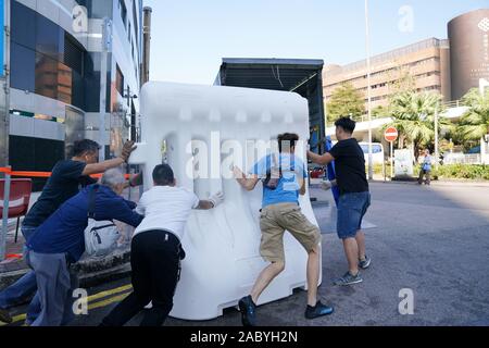 Hong Kong. 29 Nov, 2019. Supprimer les obstacles travailleurs utilisé pour bloquer la route à l'extérieur de l'Université polytechnique de Hong Kong (PolyU) dans le sud de la Chine, Hong Kong, le 29 novembre 2019. La PolyU a été remis à la direction de l'école car la police a retiré toutes les marchandises dangereuses après deux jours d'exploitation. La police se retirèrent le vendredi midi et ont levé leur cordon autour du campus, marquant la fin de l'impasse prolongée qui a duré plus de 10 jours. Credit : Wang Shen/Xinhua/Alamy Live News Banque D'Images