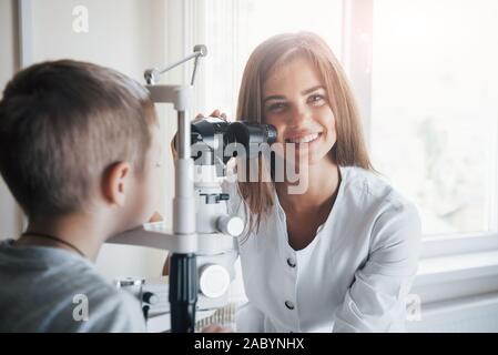 Regardez dans l'appareil photo. Contrôle de petit garçon les yeux avec de l'appareil spécial and smiling Banque D'Images