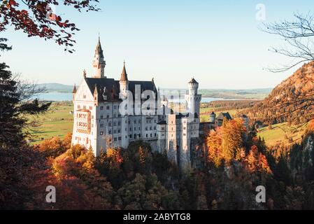 Beau château de Neuschwanstein dans sunlights et arbres de ci-dessous photographié à partir de la randonnée Banque D'Images