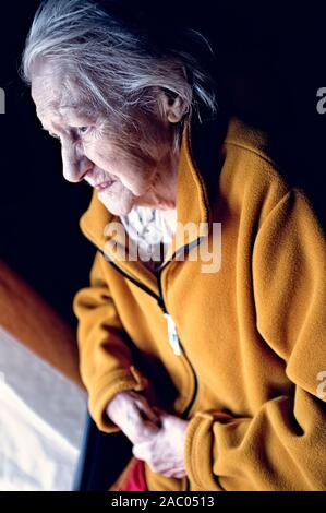 Portrait de triste solitude pensive vieux senior woman looking dans une fenêtre Banque D'Images