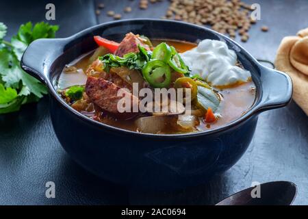 Soupe à l'ail noir hongrois avec les lentilles et la saucisse kolbassa Banque D'Images