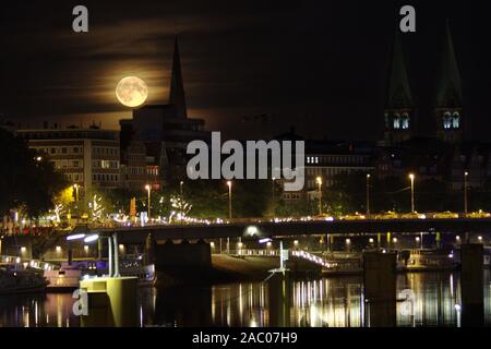 Lever de lune derrière un tour de l'église avec le fleuve Weser et la schlachte à Brême dans l'avant-plan Banque D'Images