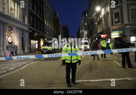 Londres, Royaume-Uni. 29 Nov, 2019. Les agents de police encercler la scène près du Pont de Londres à la suite d'une attaque à Londres, Royaume-Uni, le 29 novembre, 2019. Un knifeman a été abattu par des policiers à London Bridge le vendredi. Un certain nombre de personnes ont été tués par l'homme et l'attaque était traité comme un incident terroriste, a annoncé la police. Le Pont de Londres a été fermée. La police a également dit que le suspect portait un canular explosif. Credit : Isabel Infantes/Xinhua/Alamy Live News Banque D'Images