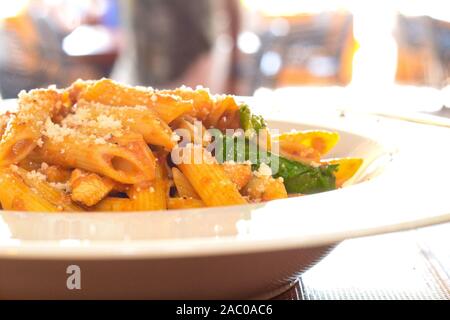 Pâtes Penne DANS LA SAUCE ARIABBATTA dans un bol blanc avec un fond bokeh Banque D'Images