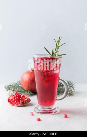 Cocktail de Noël de Grenade avec le romarin, champagne, club soda sur table béton gris. Close up. Banque D'Images