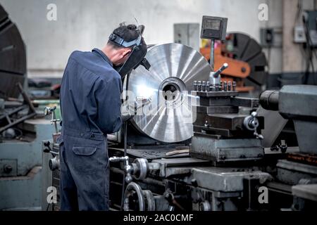 Fraisage de pièces métalliques est travailleurs tours avec les machines avec une haute précision dans le processus de travail, de la fabrication industrielle. Banque D'Images