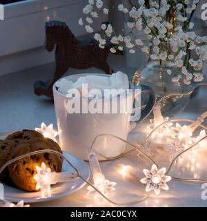 Gypsophila bouquet sur la fenêtre dans un vase de verre au crépuscule. Banque D'Images