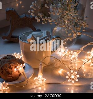 Gypsophila bouquet sur la fenêtre dans un vase de verre au crépuscule. Banque D'Images