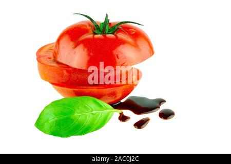 Tomates avec feuille de basilic et de vinaigre balsamique isolé sur blanc. La cuisine italienne traditionnelle concept Banque D'Images